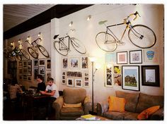 two people sitting in a room with bikes hanging on the wall