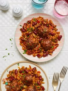 two plates filled with meatballs and rice on top of a white tablecloth next to silverware