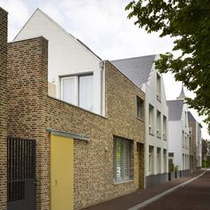 a street lined with brick buildings next to each other on either side of a yellow door