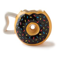 a ceramic cup with a black and yellow frosted donut on the outside, sprinkles