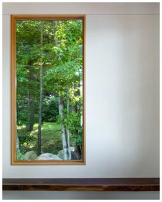 an open window in a white room with trees outside