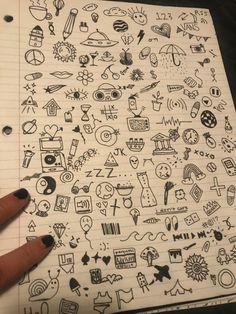 someone is holding their hand over a notebook with doodles on it