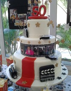 a three tiered cake decorated with photos and film reels on the top layer