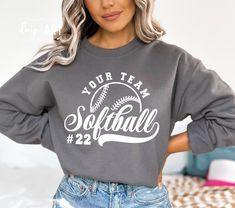 a woman wearing a sweatshirt that says your team softball