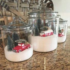 three glass jars with snow and cars in them