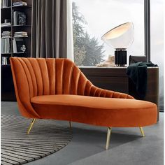 an orange chair sitting in front of a window next to a rug on the floor