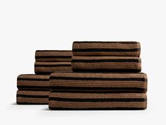 three towels stacked on top of each other in front of a white background with black and brown stripes