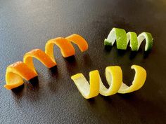 sliced oranges and lemon slices arranged in the shape of a smiley face on a black surface