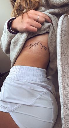 a woman with a mountain tattoo on her stomach