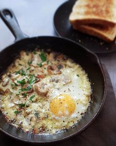 an egg is in a skillet next to some toast