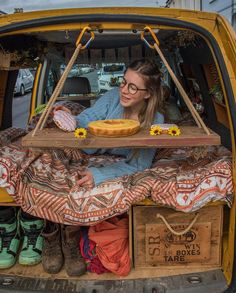 a woman sitting in the back of a yellow truck with food on it's bed