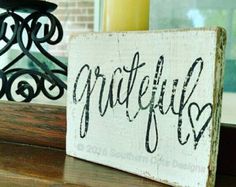 a wooden sign sitting on top of a window sill next to a candle holder