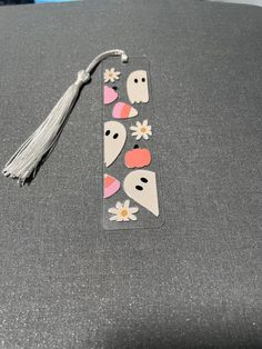 a bookmark with stickers on it and a tassel hanging from the end