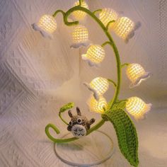 a lamp that is made to look like a plant with flowers and leaves on it