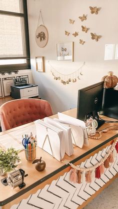 a desk with many items on it in an office space that is decorated with gold, white and pink decorations