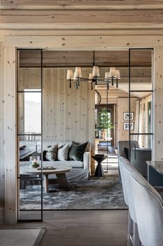 a living room filled with furniture and wooden walls