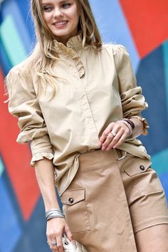 Some shirts simply make you happy the moment you slip them on. This whimsical blouse is one of them. With its ruffle-trimmed collar and sleeves adding a playful touch, this button-down beauty conjures images of twirling through a field of wildflowers on a perfect summer day. Yet its crisp cotton fabric and tailored cut mean it works just as well for that important meeting or client lunch. Versatile, flattering and mood-boosting all at once, this blouse pulls double duty as both a style staple an Spring Button-up Blouse With Smocked Cuffs, Chic Top With Button Cuffs And Ruffled Collar, Trendy Spring Blouse With Ruffled Collar, Cotton Button-up Blouse With Smocked Cuffs, Spring Blouse With Ruffle Hem For Work, Spring Workwear Blouse With Ruffle Hem, Beige Smocked Cuffs Tops For Spring, Spring Beige Tops With Smocked Cuffs, Trendy Ruffled Collar Top