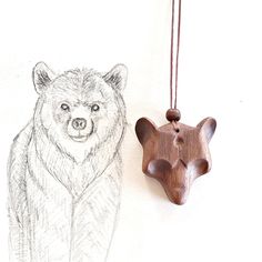 a drawing of a bear next to a wooden ornament on a white wall