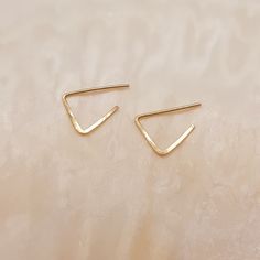 Nice little 14k gold filled earrings in the shape of a triangle.  The earrings are made of 14k gold filled wire and are hammered to keep them solid.  The total length of the earrings is 1 cm and they are sold per pair.  The earrings come with a rubber stopper, so that they stay in place.  Each earring is unique and handmade in our own studio. As a result, they may differ slightly from the photo.  Also available in a medium version. Handmade Minimalist Yellow Gold Huggie Earrings, Minimalist Handmade Yellow Gold Huggie Earrings, Gold Minimalist Handmade Cartilage Earrings, Minimalist Handmade Gold Cartilage Earrings, Minimalist Triangle Hoop Earrings As Gift, Gold Triangle Minimalist Earrings, Minimalist Gold Triangle Earrings, Handmade Minimalist 14k Gold Huggie Earrings, Handmade 14k Gold Minimalist Huggie Earrings