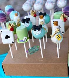 there are many cake pops with different designs on the top one is blue, green and white