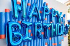 the happy birthday sign is made out of blue and orange foil balloons with letters on it