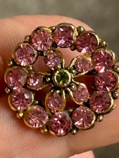 Gold tone vintage brooch with hook clasp, set with pink Rhinestones and a central green stone Vintage Pink Brooches For Evening, Pink Sapphire Brooch, Pink Vintage Evening Brooches, Vintage Pink Brooch Pin, Vintage Pink Collectible Brooches, Hook Clasp, Pink Rhinestones, Vintage Brooch, Pink Stone