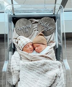 two newborn babies are wrapped in blankets and wearing mittens with the words happy holidays written on them