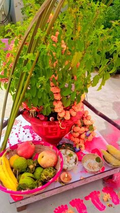 a red bowl filled with lots of different types of fruit and vegetables sitting on top of a table