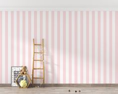 an empty room with pink and white stripes on the wall, a ladder leaning against it