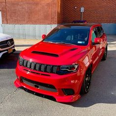 two red cars parked next to each other in a parking lot