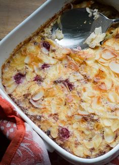 a casserole dish filled with fruit and topped with a spoon