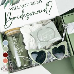 the bridesmaid gift box is packed with sunglasses, card and other personal items