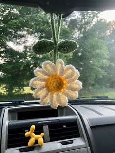 a crocheted flower on the dashboard of a car