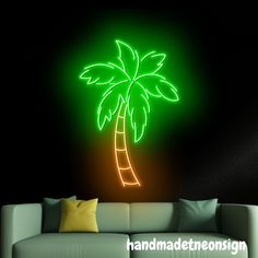 a neon palm tree on a black wall in a living room with a white couch