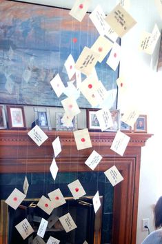 a fire place with lots of post it notes hanging from the ceiling and on the mantle