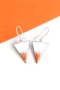 Vibrant pair of triangular earrings fired with multiple layers of white and orange enamel. These earrings have a real summer feel and would be great for carnival or the beach. Please note this item is made to order and therefore may differ slightly from the image shown due to the nature of enamel. These bright enamel triangle earrings measure approximately 23mm in length. They come with 925 Silver earring wires. The fiery coloured earrings would make the perfect gift for someone with a fire zodi Nickel-free White Summer Earrings, Nickel-free White Earrings For Summer, White Nickel-free Earrings For Summer, Summer White Nickel-free Earrings, Triangle Shaped White Jewelry For Gifts, White Triangle Jewelry Gift, White Triangle Earrings For Gift, White Triangle Jewelry For Gift, Triangle Shaped Summer Earrings For Gift