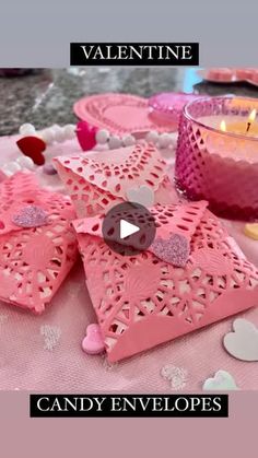 valentine's day candy envelopes on a table with candles and hearts in the background