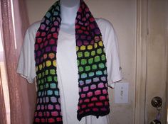 a multicolored crocheted scarf hanging on a mannequin's dummy