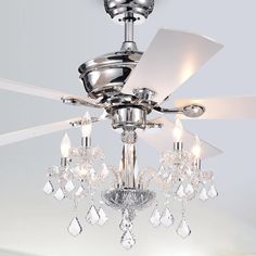 a ceiling fan with crystal chandelier hanging from it's center point in a room