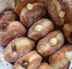 a basket filled with lots of powdered donuts covered in chocolate and marshmallows