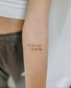 a woman's arm with a tattoo saying i love you in cursive writing