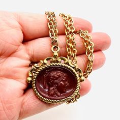 "Beautiful Vintage Large Victorian Revival Carnelian Glass Soldier Fob Necklace. Large ornate gold plated \"fob\" pendant with molded carnelian glass Roman soldier on gold plated rolo chain. In excellent vintage condition with minimal age appropriate wear. Pendant measures 1 5/8 inches tall by 1 5/8 inches wide. No chips or cracks. The heavy thick chain is 26 inches long with secure clasp. Gorgeous!!" Vintage Yellow Gold Intaglio Necklace, Gold Carnelian Necklace For Formal Occasions, Gold Carved Necklace For Formal Occasions, Gold Medallion Necklace With Carved Details, Gold Carved Victorian Necklace, Antique Gold Necklace With Carved Details, Classy Earrings, Roman Soldiers, Mystic Topaz