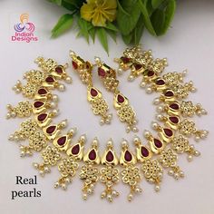 This is an exclusive high quality gold plated designer Indian wedding necklace studded with ruby and emerald stones with real tiny fresh water pearls and in a lotus flower motif. This precision-crafted necklace comes with matching pair of earrings and a complimentary gift box. The necklace is made 22k Gold plated copper, with High quality Cubic Zirconia and real Freshwater Pearls. This is a perfect gift for your beloved one and can be worn at any occasion to make you look more beautiful. This ne Anniversary Temple Jewelry With Pearl Drop, Elegant Red Kundan Gold-plated Necklace, Gold Plated Kundan Necklace With 17 Jewels For Wedding, Elegant Ruby Kundan Necklace For Wedding, Oval Gold Plated Necklace For Wedding, Gold Oval Jewelry Set For Wedding, Oval Gold Jewelry Set For Wedding, Gold Jeweled Pearl Necklace For Wedding, Elegant Heavy Gold-plated Bridal Necklace