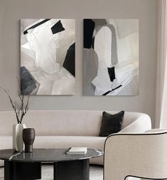 two paintings are hanging on the wall above a coffee table in a modern living room