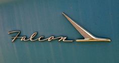 an emblem on the side of a car that is blue and has gold lettering falcon