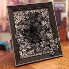 a black and white photo frame sitting on top of a wooden table