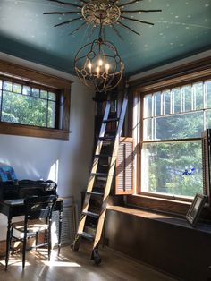 a living room filled with furniture and a chandelier hanging from the ceiling next to a window