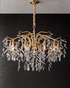 a gold chandelier with crystal drops hanging from the ceiling