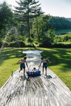 three young boys are playing on an inflatable raft