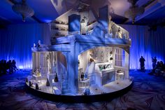 a model of a doll house on display in a room with blue lighting and curtains